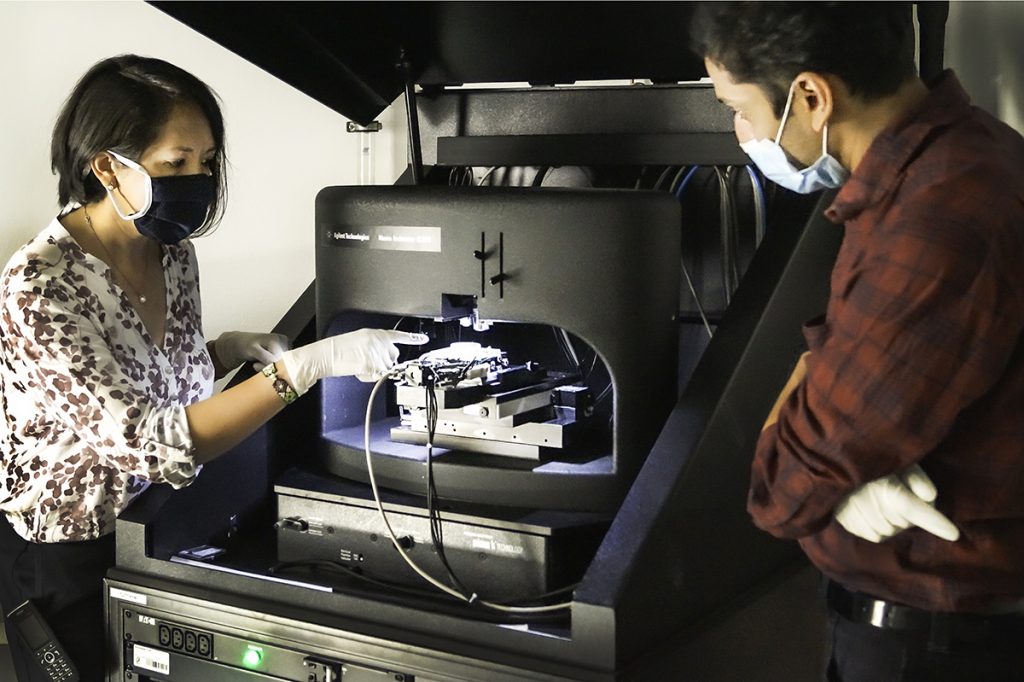 Wissenschaftler im kuenstlerische-darstellung-wasserstoffmolekuele-get-h2-initiBS-Projektlabor mit Hightech-Gerät