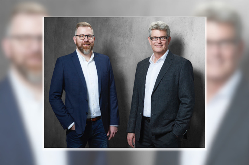 das Bild zeigt zwei weiße, bebrillte Männer im Anzug. Links im blauen Anzug steht Marc Gronau, zweiter Geschäftsbereichsleiter Bau & Europa. Er wird die Nachfolge von Geschäftsbereichsleiter Stefan Thiel (rechts, grauer Anzug) bei Nordwest antreten.