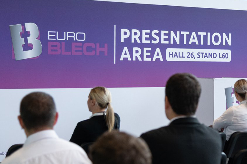 Das Bild zeigt eine Impression von der Euroblech 2022. Zu sehen sind das Logo und Besucher in der Rückansicht.