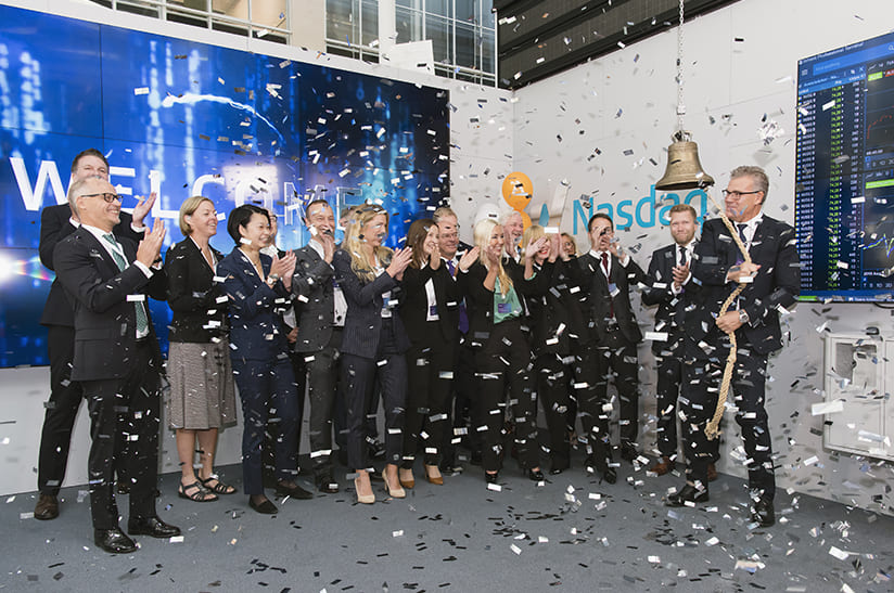 Das Bild zeigt das Führungspersonal von Alleima im Rahmen des Börsengangs. Der CEO schlägt eine Glocke, eine Gruppe Menschen applaudiert und Konfetti fliegt.