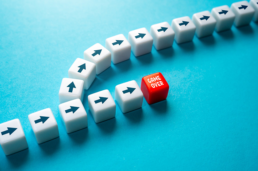 Das Bild zeigt Würfel mit Pfeilen. Die gerade aus laufende Reihe endet in einem roten Würfel, der „Game Over“ zeigt, davor zweigt eine Reihe von Würfeln ab, die dann aus dem Bild hinauslaufen. Das Moiv steht sinnbildlich für die Herausforderungen im Anlagenbau.