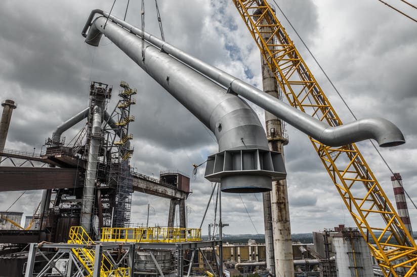 Bau der Gasreinigungsanlage von Primetals Technologies für ArcelorMittal Polen - ein 1000-Tonnen-Kran hebt das letzte Stück der herabgehenden Leitung in Position.