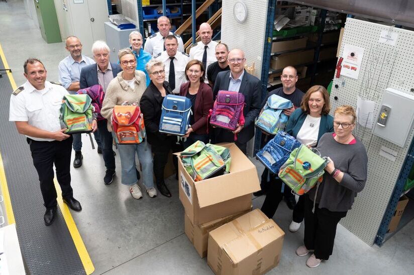 Gruppenbild Schulranzenprojekt von thyssenkrupp Steel in Zusammenarbeit mit dem Lions Club Duisburg-Concordia, dem Dezernat für Bildung, Arbeit und Soziales der Stadt Duisburg sowie der Feuerwehr. V.l.n.r: Oliver Tittmann, Amtsleiter Feuerwehr Duisburg; Klaus-Peter Müller, Dezernat für Bildung, Arbeit und Soziales, Stadt Duisburg; Hans-Martin Kokoschka, Präsident Lions Club Duisburg-Concordia; Elke Kirsch, Lions Club Duisburg-Concordia; Anna Benk, thyssenkrupp Steel Europe AG; Andrea Neubauer, Lions Club Duisburg-Concordia; Tobias Hintze, Sachbearbeiter Beschaffung Feuerwehr Duisburg; Konrad Dammeyer, stellv. Sachgebietsleiter Feuerwehr Duisburg; Christina Aumann, thyssenkrupp Steel Europe AG; Björn Gehre, Abteilungsleiter Feuerwehr Duisburg; Pascal Oberreich, TDL; Sören Link, Oberbürgermeister; Philippe Lambrecht, TDL; Nicole Sommer, Hüttenhelden e. V.; Katrin Kammann, DRK Schulsozialarbeiterin