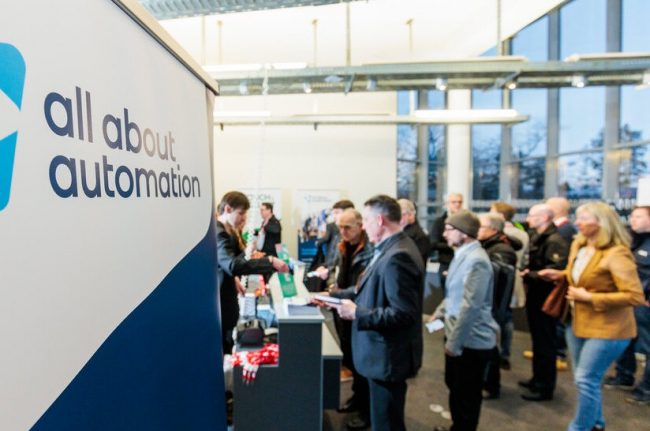 Besucher bei Stahl-Fachmesse, Verkauf von Fachmagazinen und Büchern, Banner: all about automation.