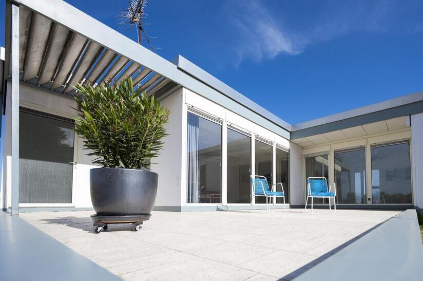 Moderne Terrasse mit Stahlkonstruktion unter blauem Himmel.