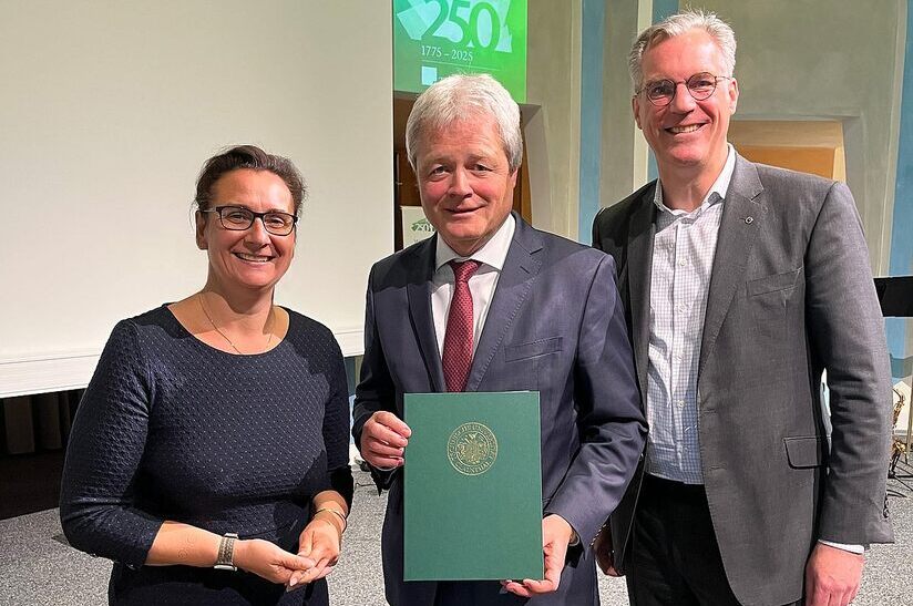 Dipl.-Ing. Ulrich Grethe (Mitte) hält die Urkunde für seine Ehrendoktorwürde in der Hand.