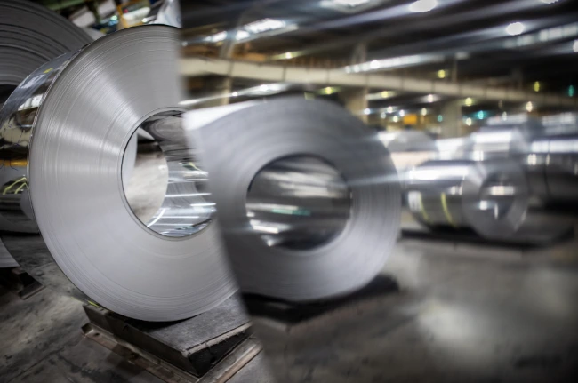 Stahlrollen in Industriehalle, Fachliteratur über Stahl und Magazinverkauf.