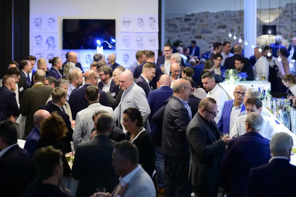 Personen diskutieren bei einer Fachveranstaltung für Stahl und Printmedien.