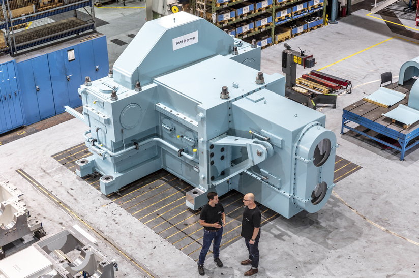 Industrieanlage in Werkshalle, zwei Männer im Gespräch.