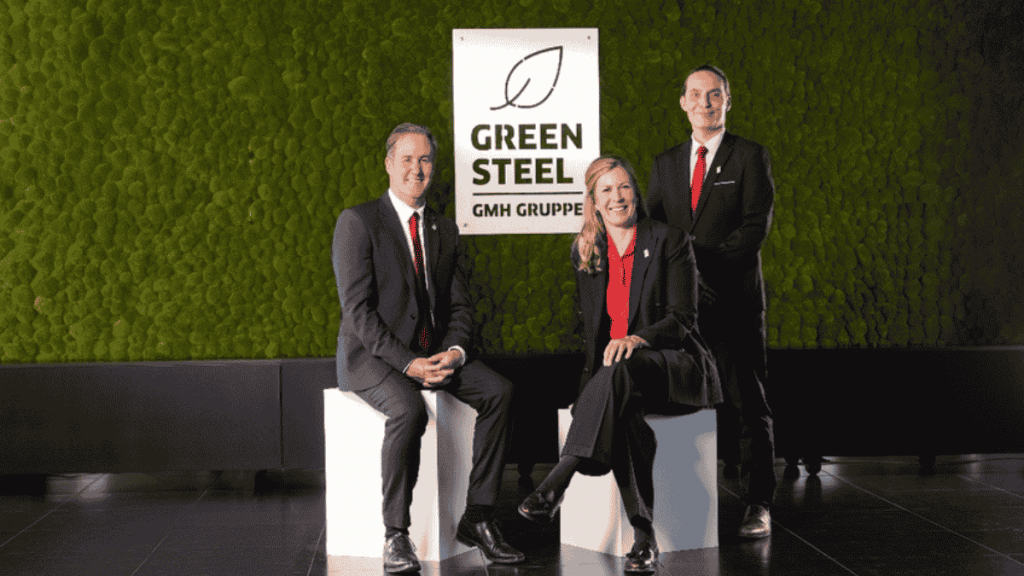 Menschen vor Green Steel-Logo der GMH Gruppe.