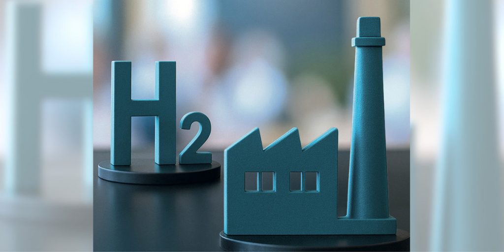 H2 und Fabrikfigur, Symbol für Stahlinnovation. Eine neue sozialwissenschaftliche Analyse des Norddeutschen Reallabors (NRL) zeigt nun, welche Faktoren den Wasserstoffhochlauf aus der Sicht von Branchenakteuren derzeit vorantreiben.