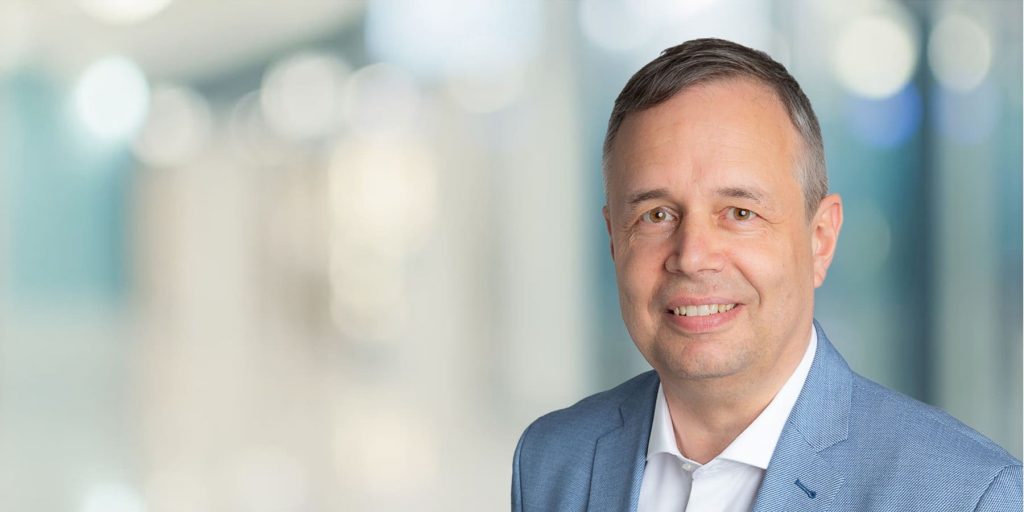 Porträt eines Mannes in Anzug (Martin Sisolak), Hintergrund unscharf.