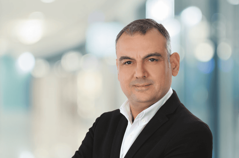 Mann im Anzug, Hintergrund unscharf, Stahlindustrie. Es ist Ozan Hünler.