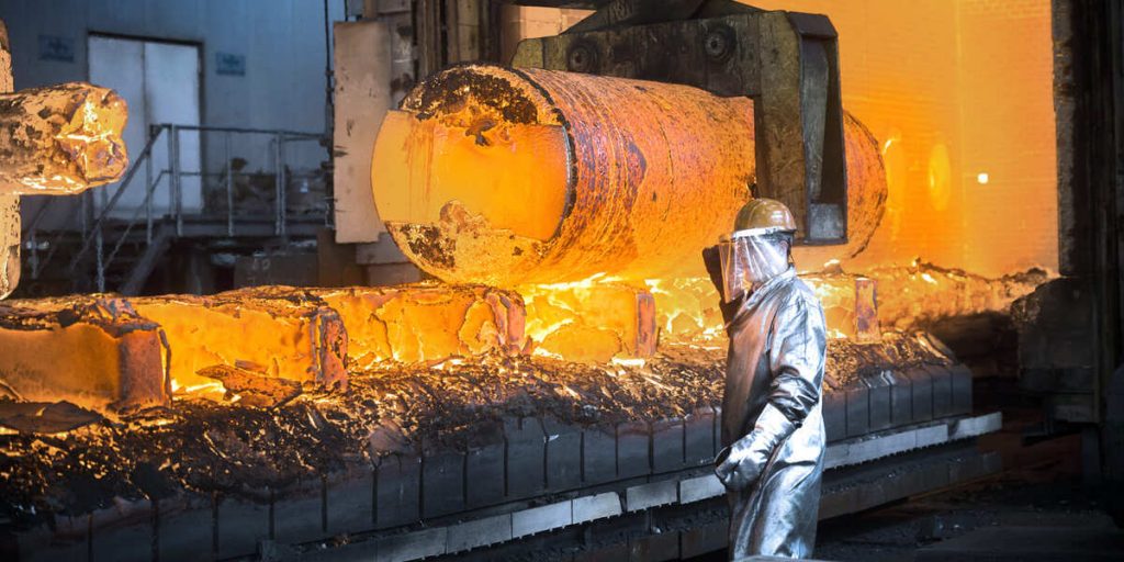Heißes Stahlwerk mit Arbeiter in Schutzkleidung, Fokus auf Stahlproduktion.