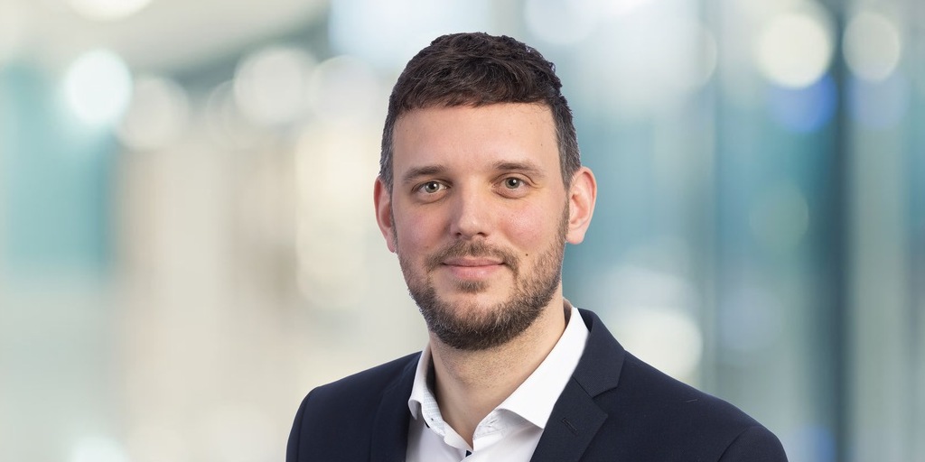 Das Bild zeigt Kai Marwig vor einem verschwommenen Hintergrund.